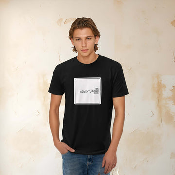 Young man wearing a black slim-fit t-shirt with "BE ADVENTUROUS" printed, showcasing a casual and adventurous style.